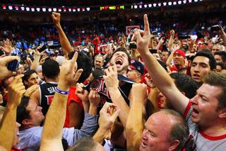 UNLV forward Carlos Lopez celebrates the Rebels' upset of UNC with a court full of fans at the Las Vegas Invitational championship game Saturday, Nov. 26, 2011, at the Orleans Arena. UNLV beat the No. 1-ranked Tar Heels 90-80.