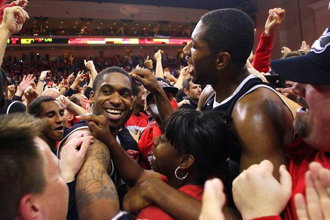 UNLV's Oscar Bellfield, left, and Mike Moser are mobbed by fans after defeating the University of North Carolina during the Las Vegas Invitational championship game Saturday, Nov. 26, 2011, at the Orleans Arena. The Rebels upset the No. 1-ranked Tar Heels 90-80.