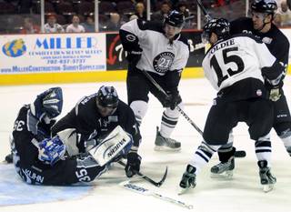 Idaho Steelheads defenseman Derek Matheson (11) assists sprawling goaltender Jerry Kuhn by protecting the puck from Wrangler attackers Josh Lunden, center, and Ash Goldie as they sit on the doorstep of the crease waiting for a rebound during the waning minutes of the third period of play on Friday night.