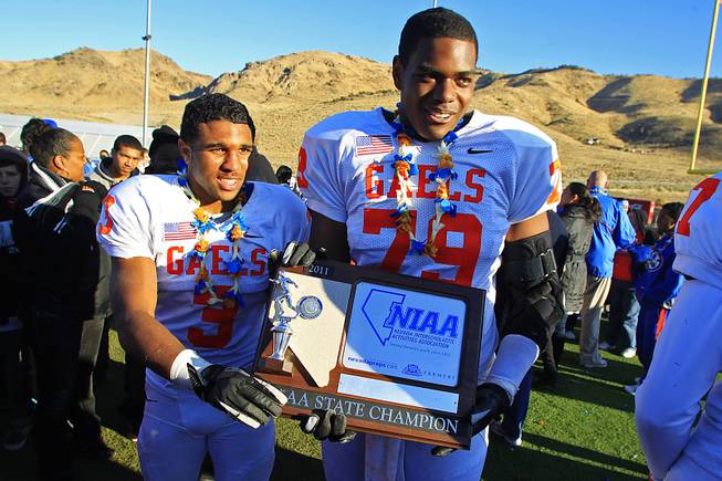 Bishop Gorman's Shaquille Powell, left, and Ronnie Stanley show off their trophy after beating Reed High School 72-28 for the 4A football championship Saturday, Dec. 3, 2011 at Damonte Ranch High School in Reno.