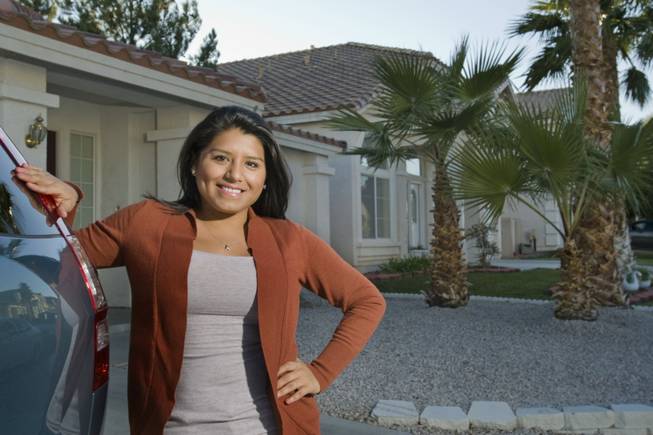 Allison Cordova poses outside of her home Monday, Dec. 5, 2011. Cordova, who closed on the home in October, said homeownership seemed to make sense when mortgage payments rivaled rental rates. 