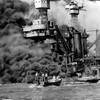In this Dec. 7, 1941, file photo, a small boat rescues a crew member from the water as heavy smoke rolls out of the stricken USS West Virginia after the Japanese bombing of Pearl Harbor, Hawaii. Two men can be seen on the superstructure, upper center. The mast of the USS Tennessee is beyond the burning West Virginia. Wednesday marks the 70th anniversary of the attack that brought the United States into World War II. 