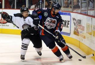 Wrangler defenseman Barry Goers (6) leans into Ontario Reign skater Bill Bagron along the boards during the third period of play on Thursday night at the Orleans Arena.
