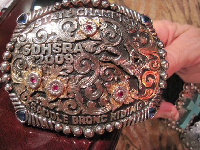 Sindi Jandreau shows the buckle of her son, a 2009 high school rodeo champion from South Dakota.