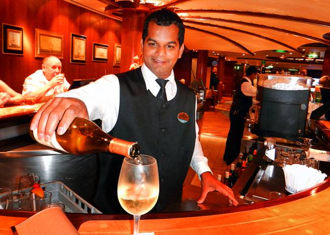In Dubai, United Arab Emirates, a bartender on the Brilliance of the Seas cruise ship pours a glass of wine while in port. December  2011.