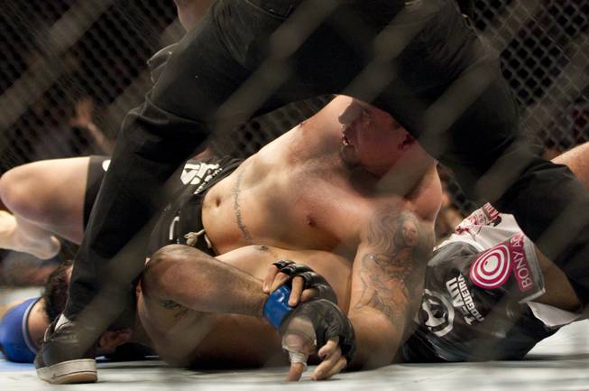 Minotauro Nogueira, bottom, has his arm broken by Frank Mir during UFC 140 in Toronto on Saturday, Dec. 10, 2011.