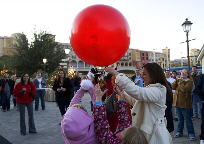 Amanda Gibbs, right, development director of Boys Town catches a balloon during the 7th day of the 12 days of Christmas at the Village at Lake Las Vegas Monday, Dec.18, 2011. A "swan" attached to each balloon holds play money that represents a charitable donation. The donations went to DJ's Community Christian Academy, St. Judes and Boys Town. In12Days is a volunteer-based project aiming to bring the 12 days of Christmas to unsuspecting people in the Las Vegas Valley.