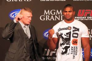 Brock Lesnar, left, and Alistair Overeem pose for photographers during a news conference Wednesday, Dec. 28, 2011 in advance of UFC 141 on Friday.