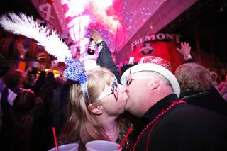 Troy and Tracy Neujahr, of Nebraska, kiss during TributePalooza at the Fremont Street Experience in downtown Las Vegas on New Year's Eve just after midnight on Sunday, Jan. 1, 2012.