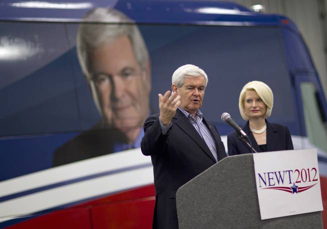 Republican presidential candidate former House Speaker Newt Gingrich, left, accompanied by his wife, Callista, gestures during a campaign stop, Monday, Jan. 2, 2012, in Walford, Iowa.