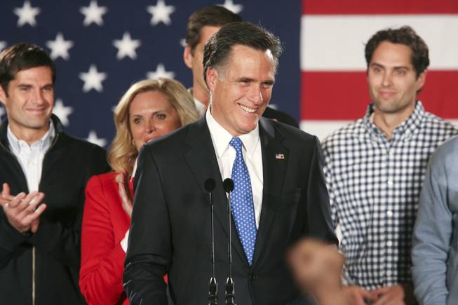 Former Massachusetts Gov. Mitt Romney, a candidate for the Republican presidential nomination, speaks at his caucus night event with his wife, Ann, and sons in Des Moines, Iowa, on Jan. 4, 2012. 