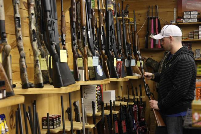 Customers at the State Line Gun Store in Mason, N.H., on Jan. 6, 2012, inspect rifles. Gun stores in New Hampshire, where residents are protective of their Second Amendment rights, are like casinos in Nevada: a mecca that draws customers from neighboring states. 