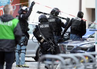 German special police force officers leave the area of the Old City Hall in Ingolstadt, Germany, Aug. 19, 2013, where a man has taken several hostages in the city hall. Police could arrest the hostage taker and free his captives unharmed. 
