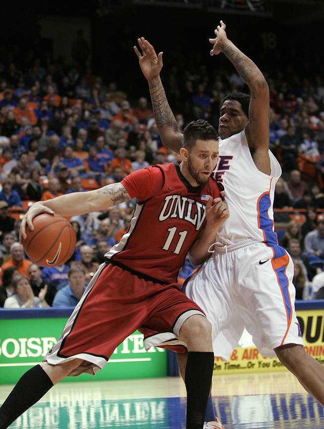 UNLV's Carlos Lopez (11) drives past Boise State's Kenny Buckner (42) during the first half of an NCAA college basketball game Wednesday, Jan. 25, 2012, in Boise, Idaho.   (AP Photo/Matt Cilley)