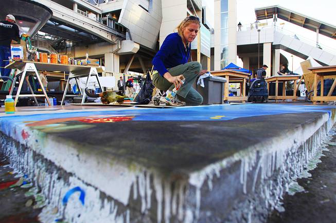 Artist Stephanie Waxali sprays a water-based stain on concrete during  the World of Concrete convention Wednesday, Jan. 25, 2012.