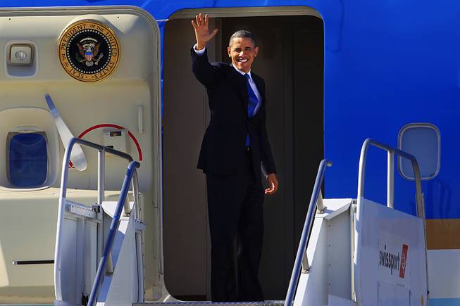 President Obama waves to the media before boarding Air Force One at McCarran International Airport after a visit to Las Vegas Thursday, Jan. 26, 2012.