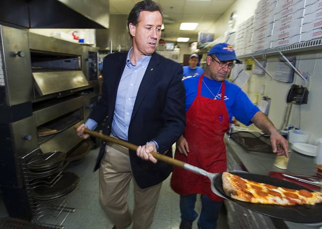 Republican presidential candidate former Pennsylvania Sen. Rick Santorum serves up a slice of pizza with owner Ben Sitto at Manhattan Pizza, a pizza shop by his Nevada headquarters, in Las Vegas on Jan. 31, 2012.