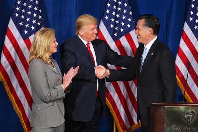 Republican presidential candidate Mitt Romney, right, shakes hands with Donald Trump after Trump endorsed Romney's presidential bid Feb. 2, 2012, at the Trump International Hotel in Las Vegas. Romney's wife, Ann, applauds.