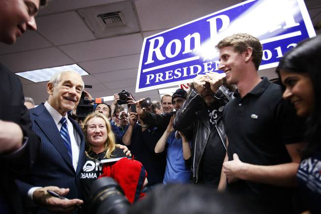 Rep. Ron Paul poses for photos while campaigning at American Shooters, an indoor gun range and retail store in Las Vegas Friday, Feb. 3, 2012.