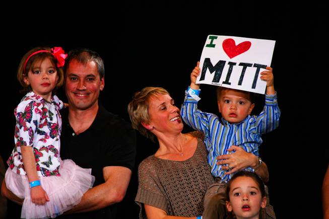 In the arms of his mom, Tommy Sholeff holds an "I love Mitt" sign in support of Republican presidential candidate Mitt Romney while attending the Nevada Republican caucus Saturday, Feb. 4, 2012, at the Red Rock Hotel and Casino in Las Vegas.  From left, Emily, Jim, Amy, Tommy and Katie Sholeff.