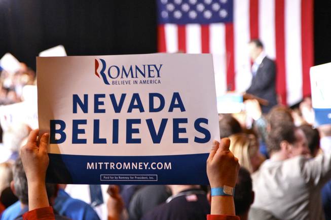 A Mitt Romney supporter holds a sign up at Red Rock Resort, where Romney held his victory party.