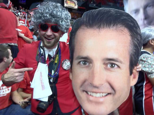 UNLV student Joey Shea holds up a giant cutout of Dave Kirvin's head, because an important college basketball game calls for such.