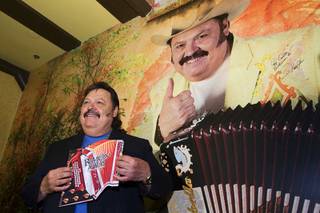 Ramon Ayala holds an accordion-shaped menu as he poses by a image of himself during the grand opening of Ramon Ayalas Cocina & Cantina at Buffalo Bills Resort in Primm Thursday, Feb. 16, 2012. Known as the 