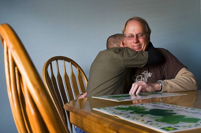 Donald Munn gets a hug from his disabled adopted son Brian, 21, at their home in Henderson Thursday, March 8, 2012. Munn, a former Clark County firefighter, says the fire department fired him for abusing sick leave but Munn says he needed to take the sick leave to care for his son. Brian Munn suffers from fetal alcohol syndrome.