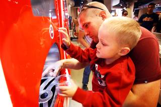 Brad Stewart helps his son Steven Stewart, 5, both of Salt Lake City, Utah, pour some root beer using the Coca-Cola Freestyle machine at the World of Coca-Cola on The Strip in Las Vegas on Friday, March 9, 2012.
