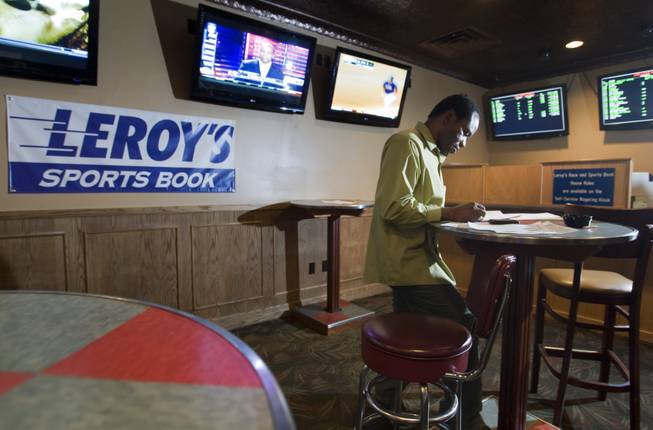 Kevin Ehiemere of Riverside, Calif. looks over a  college basketball betting sheet in the Hooters sports book Tuesday, March 13, 2012. 