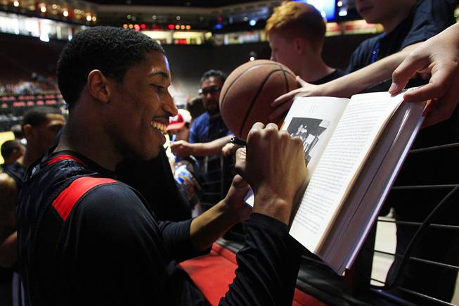 Justin Hawkins signs a copy of the book "Play Their Hearts Out," in which he is featured, after practice before their second round NCAA Men's Basketball Championship game Wednesday, March 14, 2012 at The Pit in Albuquerque.