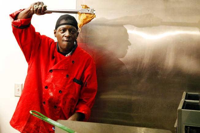Flavor Flav prepares chicken during the grand opening of Flavor Flav's House of Flavor in Las Vegas on Thursday, March 15, 2012.