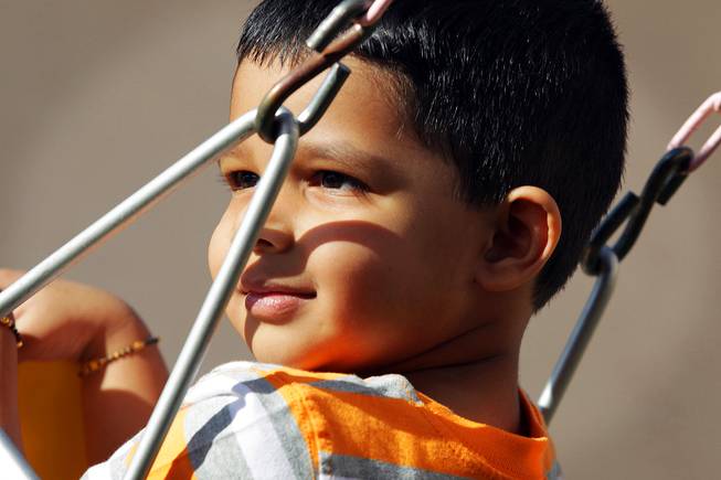 Vinil Narayan, 2, who is autistic, plays on the swing while learning communication with his mother Shika Narayan during a session with Jennifer Murdock, a developmental specialist with Easter Seals Nevada, outside his home in Henderson on Friday, March 16, 2012.