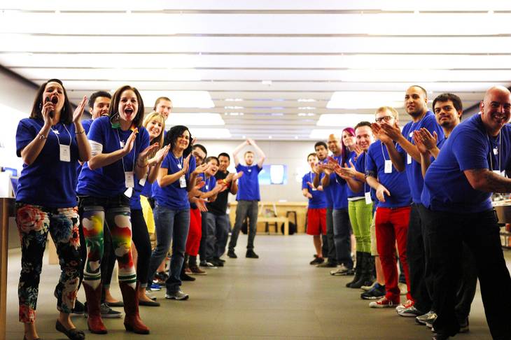 Apple employees cheer as the first customer enters the store to purchase the new iPad at the Apple Store inside the Forum Shops at Caesars in Las Vegas on Friday, March 16, 2012.