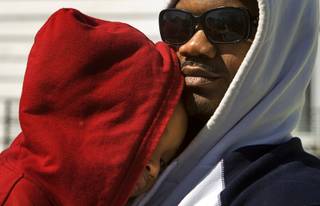 Braylyn Moffett, 4, is held by his father Antoine Moffett as he tries to stay awake for a 