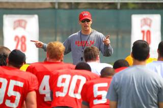 Coach Bobby Hauck talks to his team during football practice March 30, 2012.