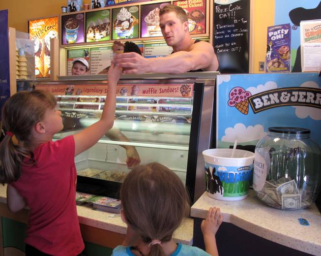 Chippendale Kyle Efthemes hands a sweet treat to Sydney Kellar, 7, at Ben & Jerry's at The District. It was free-cone day to celebrate the company's 34th anniversary.