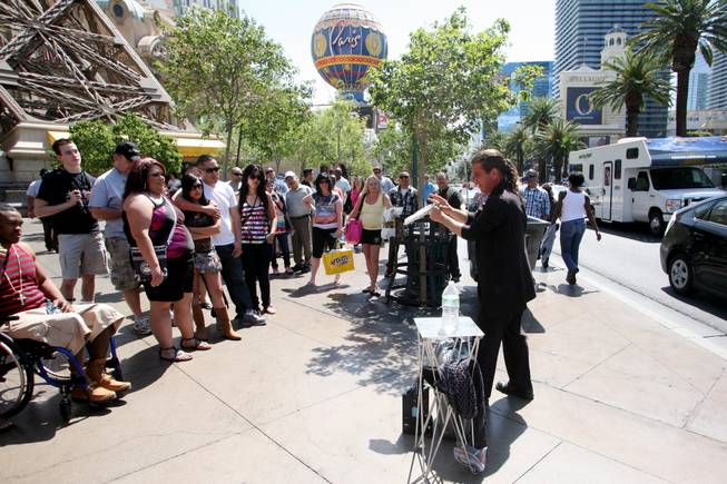 Magician Jungle Josh performs for a crowd in front of Paris on Saturday, April 7, 2012.