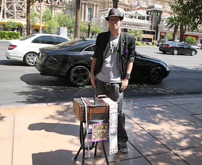 Street magician Grndl poses with his magic set-up after wrapping up a day of performing in front of the Bellagio fountains on Saturday, April 7, 2012.