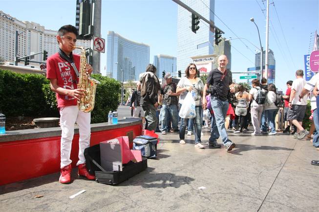 Diego Morales, 12, plays pop favorites on his alto sax for passersby on the Strip on Saturday, April 7, 2012.