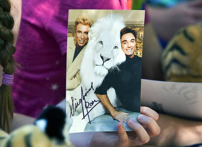 A child holds an autographed photo of Siegfried & Roy ...