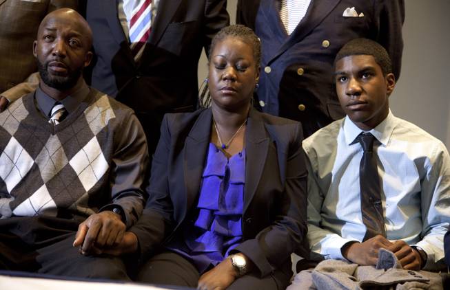 The mother of Trayvon Martin, Sybrina Fulton, center, closes her eyes as she watches a news conference with special prosecutor Angela Corey in Sanford, Fla., announcing charges against George Zimmerman with Trayvon Martin's father Tracy Martin, left, and Trayvon's brother Jahvaris Fulton, on Wednesday, April 11, 2012, in Washington.