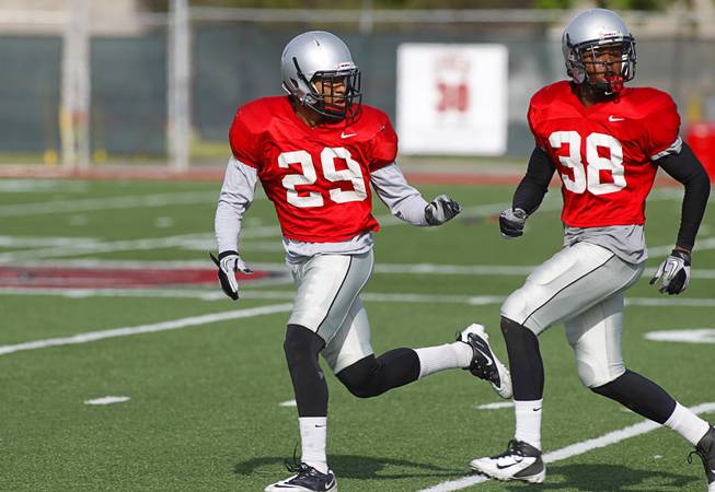 Tajh Hasson, left, covers Mike Horsey during practice at UNLV's Rebel Field, April 16, 2012. 