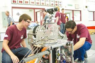 Chad Pesquera, at left, and Joseph Mauro of Cimarron Memorial High School work on their competition robot 