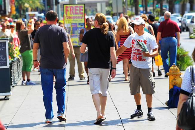 A man hands out advertisements for "entertainers" on the Strip Saturday, April 28, 2012.