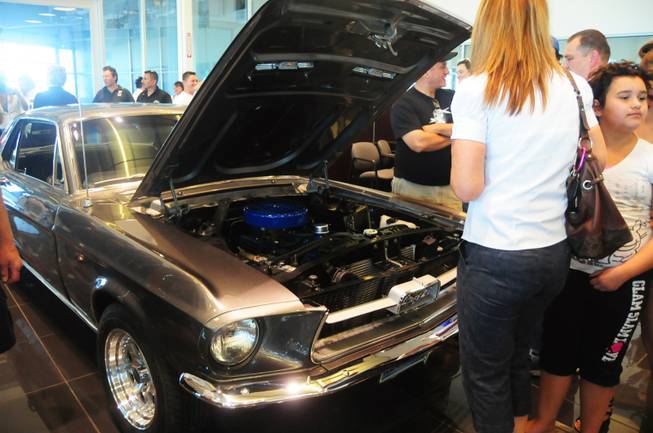 Attendees take look around Vanessa's refurbished 1967 Ford Mustang coupe on Saturday, April 28, 2012. The 17-year-old Centennial High School senior, who was born with a congenital heart condition, was the recipient of a car makeover courtesy of the local Make-A-Wish Foundation and its partners.