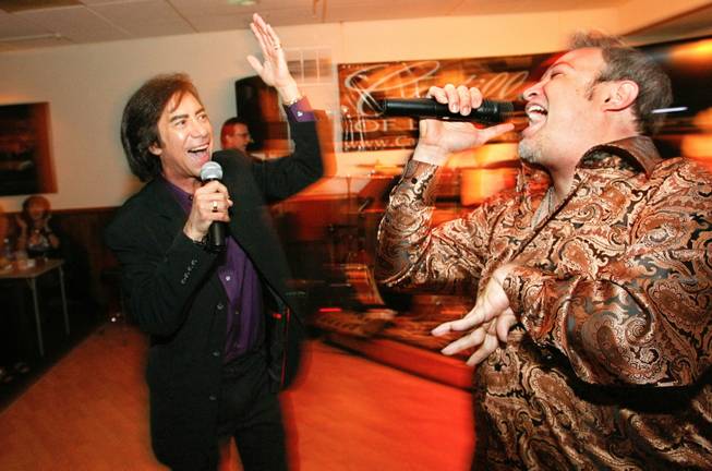 Rob Garrett, a Neil Diamond impersonator, is joined by singer Mark Giovi as they perform the song, "Sweet Caroline" during Monday night open mike at the Tap House in Las Vegas, Nevada on April 23, 2012. Giovi, who has cerebral palsy, is the emcee of the weekly show. 
