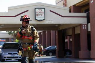 City of Las Vegas firefighter captain crosses Fremont Street to talk to a Batalion Chief as firefighters respond to a fire at the City Center Motel, on the northeast corner of Fremont Street and Seventh Street, in downtown Las Vegas Tuesday, May 8, 2012.
