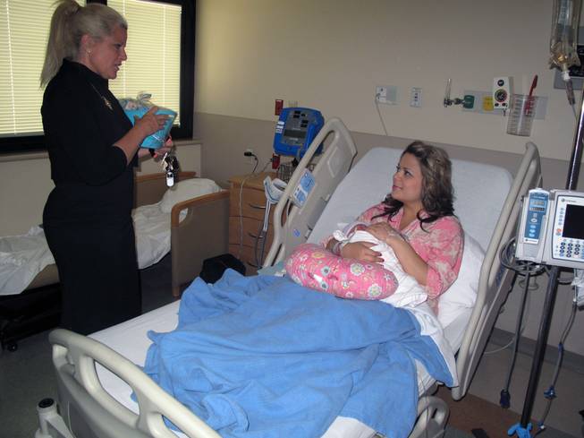 Jeanne Cosgrove, director of SAFE KIDS at Sunrise Children's Hospital, hands new mom Mary Wernert a basket of safety items in honor of Mother's Day. Hours earlier, Wernert gave birth to her daughter, Madeline Isabella.