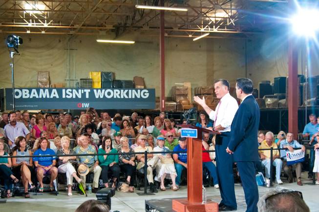 Presidential hopeful Mitt Romney, and Nevada Governor Brian Sandoval at right, address supporters during a campaign rally at a local business, Tuesday May 29, 2012.